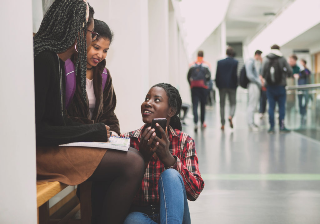 Students looking at the phone and smiling