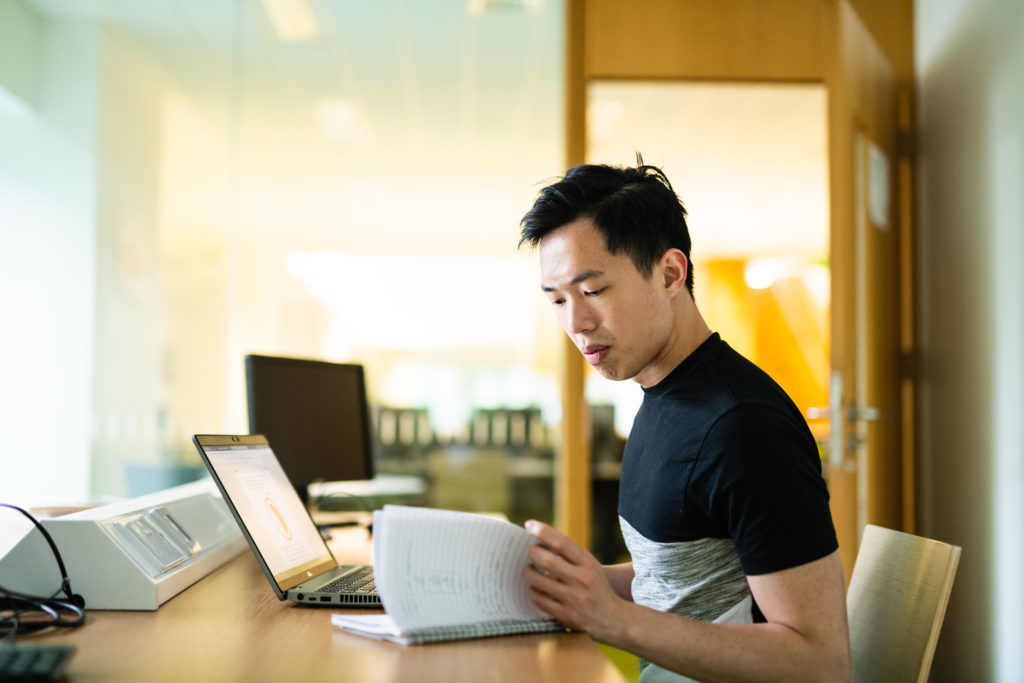 A student working on his assignment on a laptop